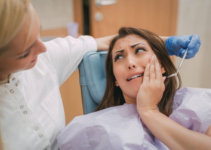 Gece saatlerinde diş ağrısı yaşayan bir bireyin çene ve yüz bölgesini tutarken gösteren görsel.