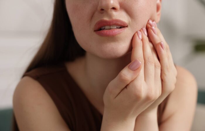 Soğuk ve sıcak yiyecekler tüketirken diş hassasiyeti yaşayan bireyi gösteren bilgilendirici ağız sağlığı görseli.