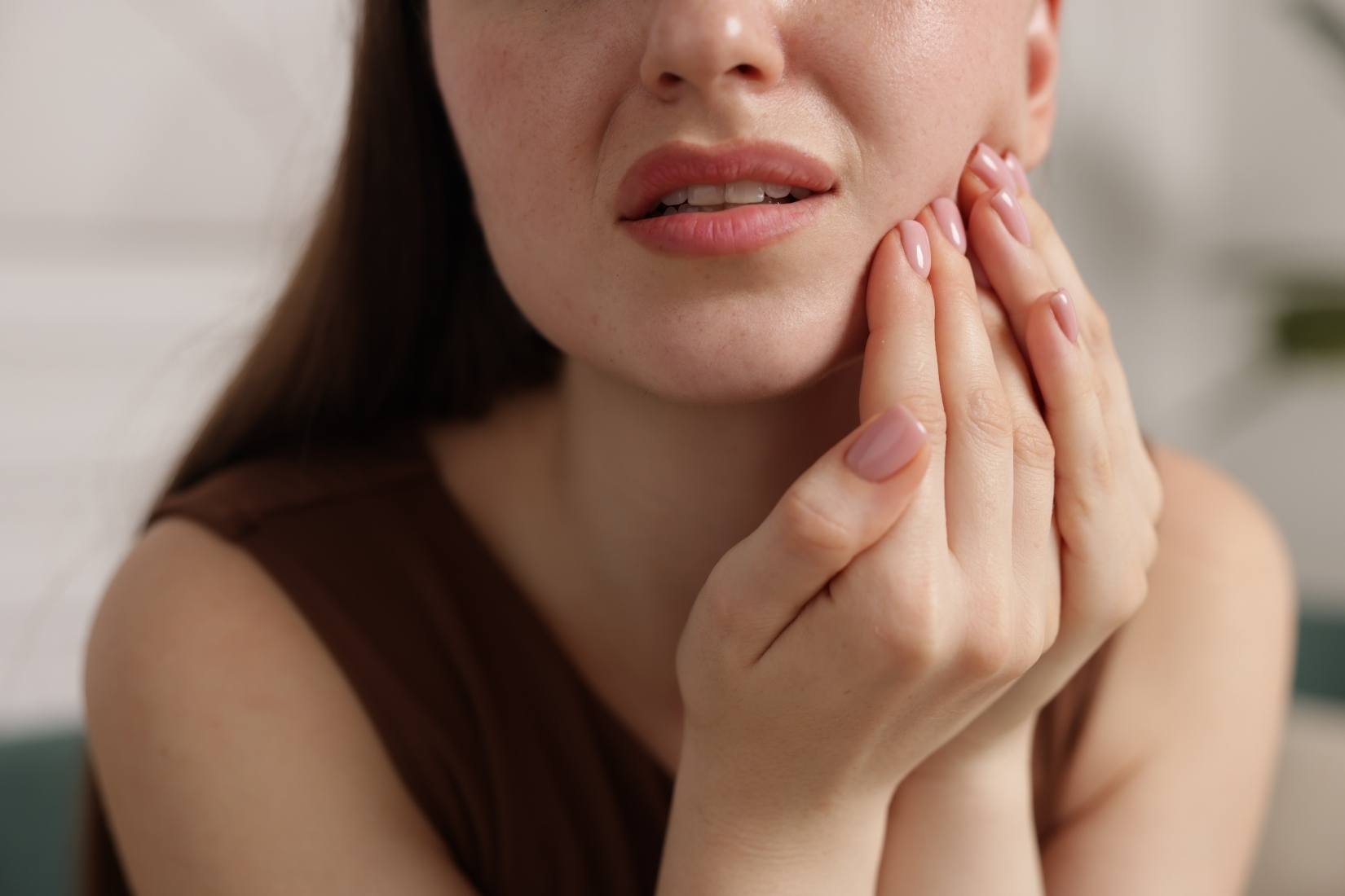 Soğuk ve sıcak yiyecekler tüketirken diş hassasiyeti yaşayan bireyi gösteren bilgilendirici ağız sağlığı görseli.