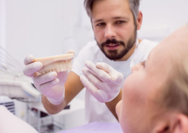 Alt çeneye yerleştirilen implantlar üzerine oturan overdenture protez sistemini gösteren diş hekimliği görseli.