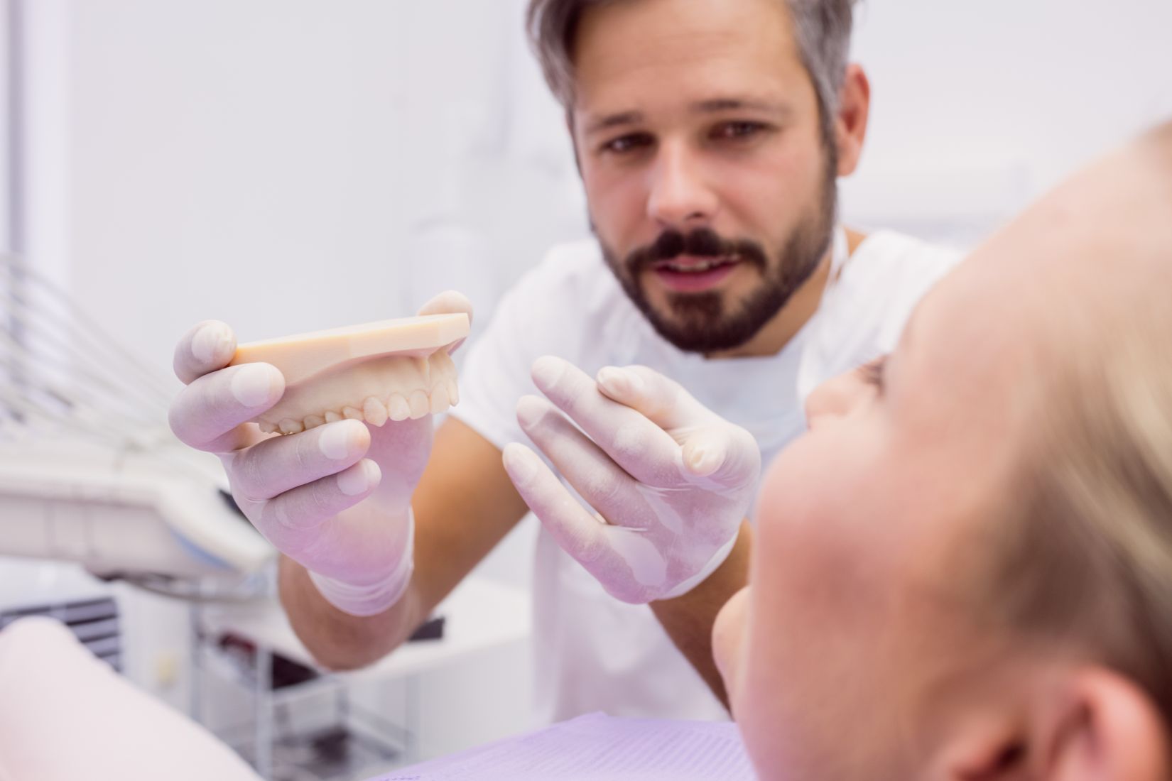 Alt çeneye yerleştirilen implantlar üzerine oturan overdenture protez sistemini gösteren diş hekimliği görseli.